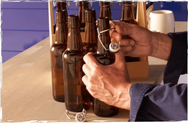[Translate to Englisch:] Installation der Bügelverschlüsse an den Flaschen